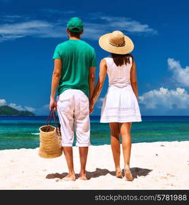 Couple relaxing on a tropical beach at Seychelles, La Digue.