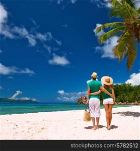 Couple relaxing on a tropical beach at Seychelles, La Digue.