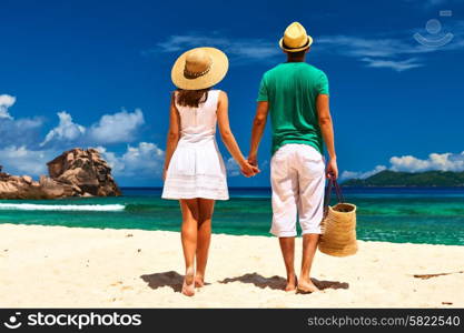 Couple relaxing on a tropical beach at Seychelles, La Digue.