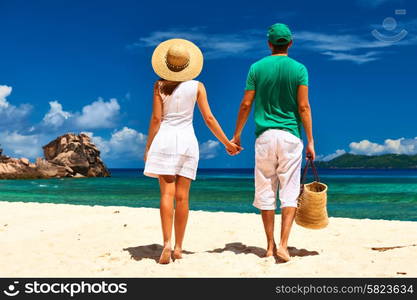 Couple relaxing on a tropical beach at Seychelles, La Digue.