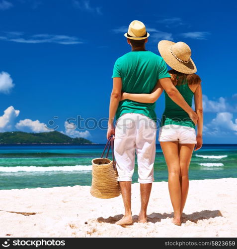 Couple relaxing on a tropical beach at Seychelles, La Digue.