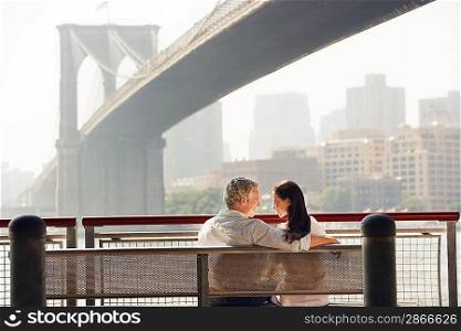 Couple Relaxing on Bench under Bridge
