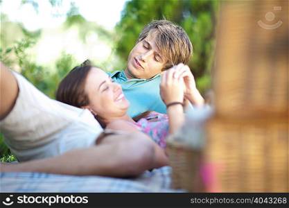 Couple relaxing on picnic blanket