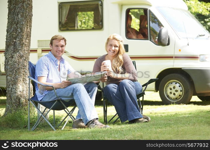 Couple Relaxing Outside Motor Home On Vacation