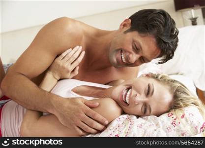 Couple Relaxing Together In Bed