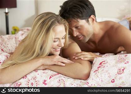 Couple Relaxing Together In Bed