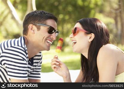 Couple Relaxing Together In Garden Eating Ice Lolly