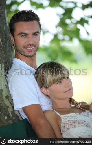 couple relaxing under a tree