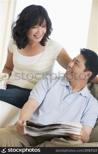Couple relaxing with a newspaper and smiling