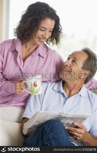 Couple relaxing with a newspaper smiling