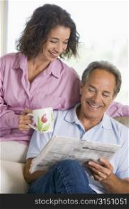 Couple relaxing with a newspaper smiling