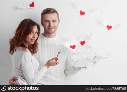Couple releasing love, man and woman open cage with winged hearts, valentines day concept. Couple releasing love