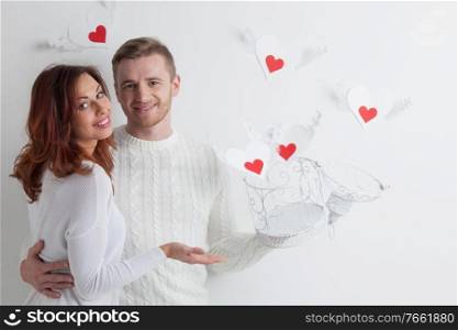 Couple releasing love, man and woman open cage with winged hearts, valentines day concept. Couple releasing love hearts