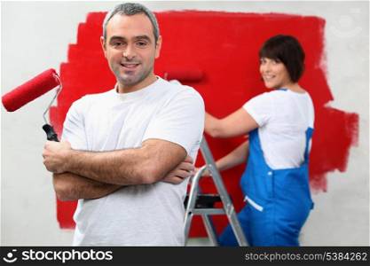 Couple repainting home walls in red