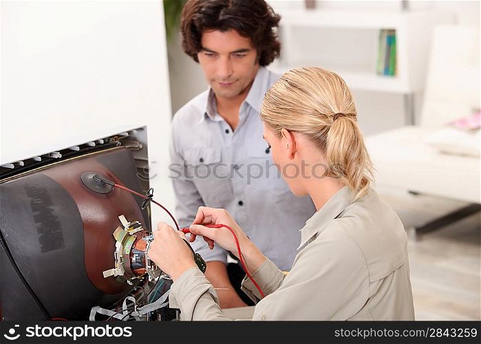 Couple repairing old television
