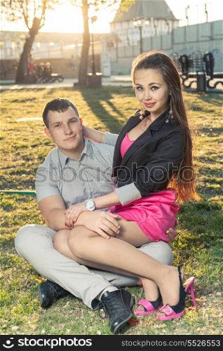 Couple resting on a green grass backlit colorized image
