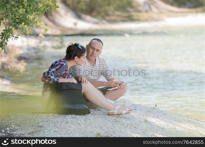 couple resting on the river banks