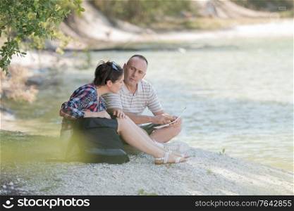 couple resting on the river banks