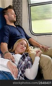 Couple resting with eyes closed in train sleeping woman man