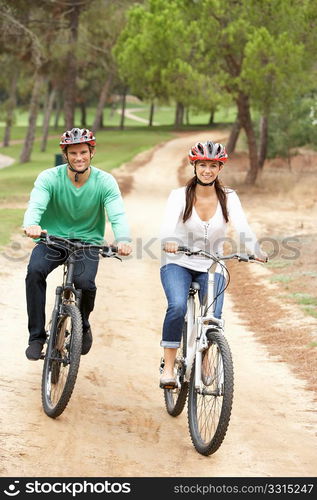 Couple riding bicycle in park