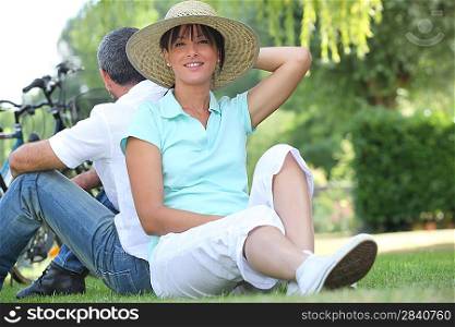 couple riding bikes and relaxing in the park