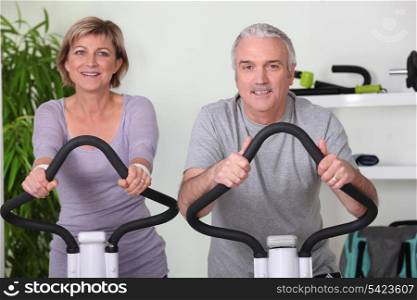 Couple riding exercise bikes