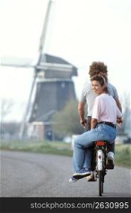 Couple riding together on bicycle, Holland