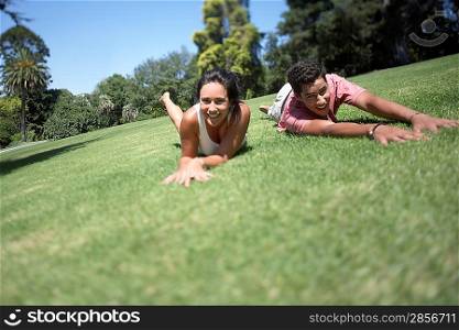 Couple rolling on grass in park
