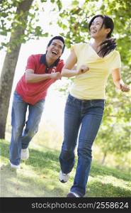 Couple running and being playful outdoors smiling