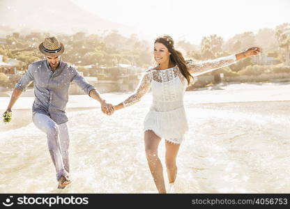 Couple running and splashing in sea, Cape Town, South Africa