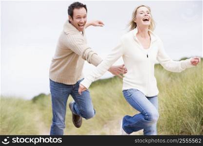 Couple running at beach smiling