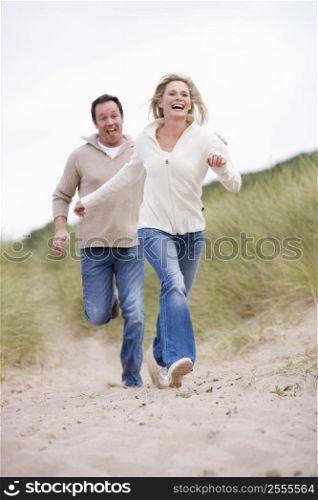 Couple running at beach smiling