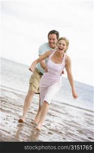Couple running at the beach smiling