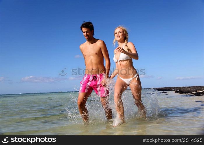 Couple running in sea water
