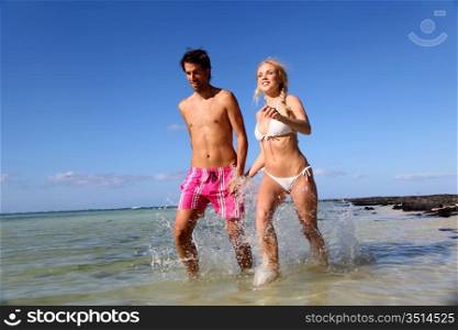 Couple running in sea water