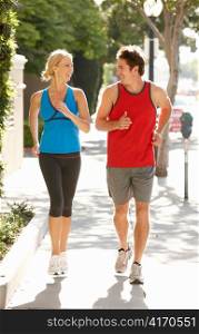Couple running on city street