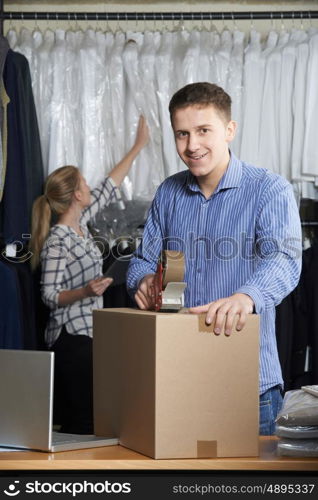 Couple Running Online Clothing Store Packing Goods For Dispatch