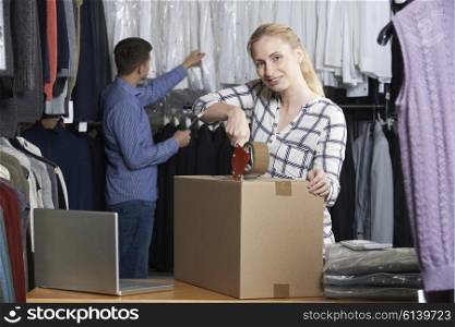 Couple Running Online Clothing Store Packing Goods For Dispatch