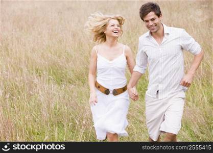 Couple running outdoors holding hands smiling