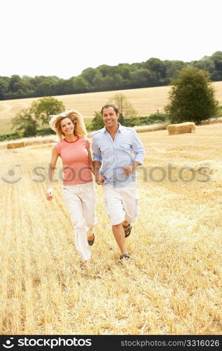 Couple Running Together Through Summer Harvested Field