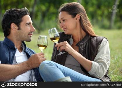 Couple sampling wine whilst visiting vineyard