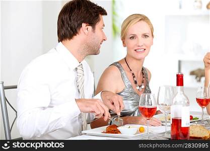 Couple sat at table eating meal