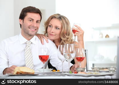 Couple sat at table with wine