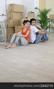 Couple sat back to back on floor