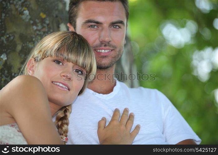 Couple sat by a tree