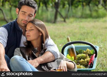 Couple sat by basket full of grapes