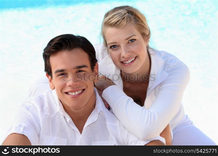 Couple sat by swimming pool
