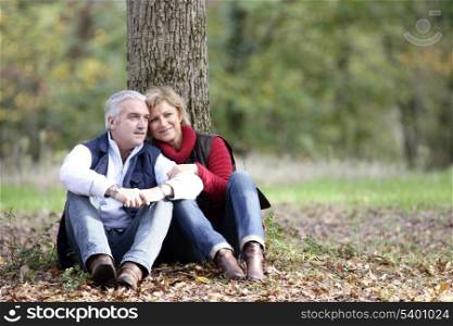 Couple sat by tree