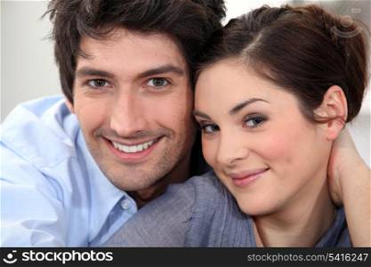 Couple sat hugging at home