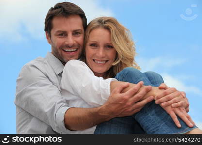 Couple sat hugging each other in park